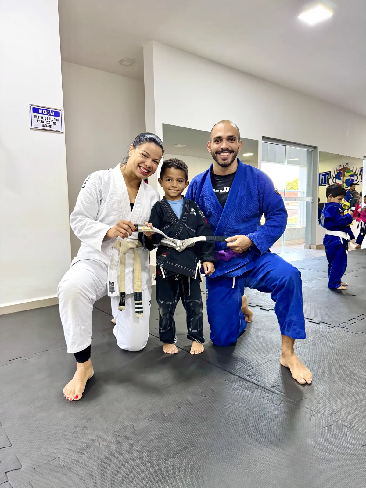 Criança do Jiu Jitsu kids com professores do CT